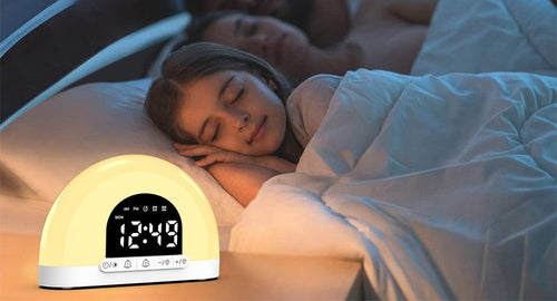 Réveil simulateur d'aube posé sur une table de nuit, enfant endormi